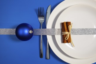 Two white plates and Christmas decoration on the blue wooden table.Top view.Flat Lay Image