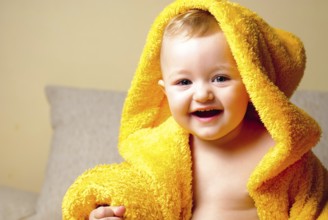 Girl after bathing, sitting in yellow bathrobe