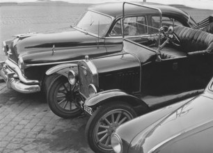 In the 1950s. Cars are parked beside each other and they are from different eras. An american