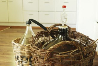 Bottles of homemade wine in wicker baskets