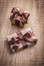 Two vintage gift boxes with brown bows on old wooden board