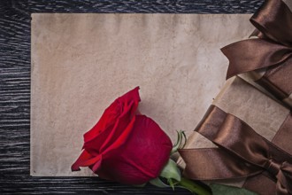 Vintage paper red expanded rose wrapped giftboxes on wooden board