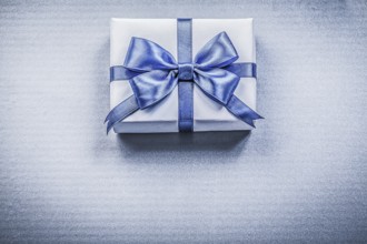 Packed present box with bow on blue background holidays concept