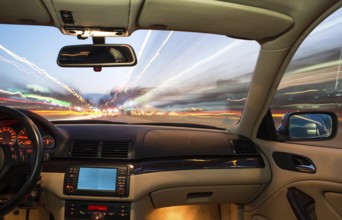 Car interior on driving. Blurred night lights