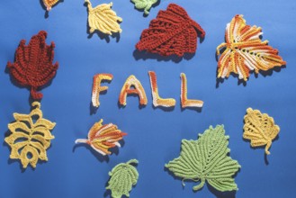 Knitted autumn leaves on blue textile
