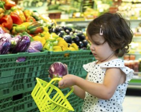 Child shopping eggplants in supermarket. Concept for buying fruits and vegetables in hypermarket.