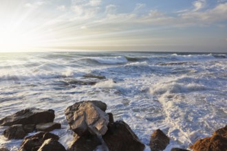 Magnificent sunset on Mediterranean sea. Storm waves break about breakwater stones on quay. Tel