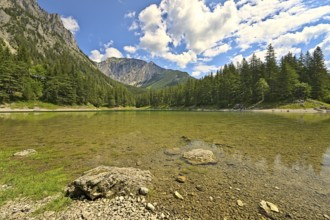 Green Lake in Styria during a summer day with people walking around the waterside