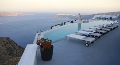 Roof garden of a holiday resort hotel against the ocean at sunset. Oia village, Santorini Island,