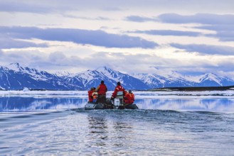 People travelling in inflatable boat at Svalbard