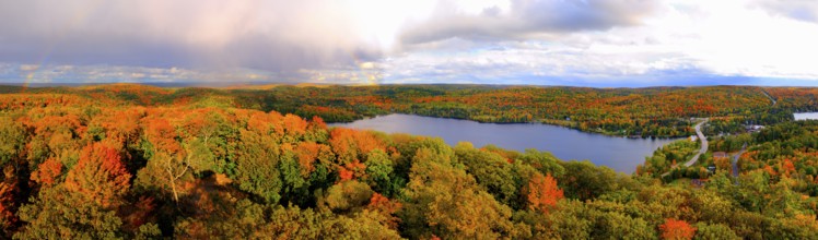 Aerial panoramic view of Lake of Bays and colorful fall forest during sunset with a trace of a
