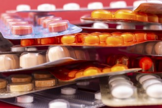 Different colorful capsules and pills in plastic packs - blisters stacked. Global pharmaceutical