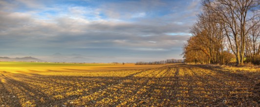 Autumn morning landscape over the city of Louny. Autumn plowed field at amazing sunrise. Czech