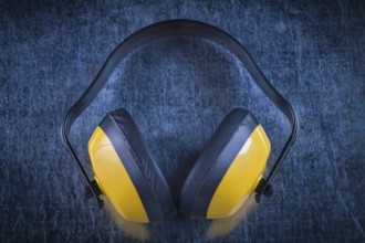 Noise reduction earmuffs on metallic surface construction concept