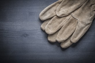 Leather working gloves on dark board