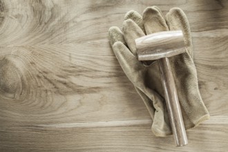 Safety gloves lump hammer on wooden board
