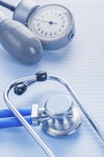 Stethoscope and blood pressure monitor on blue background medical concept