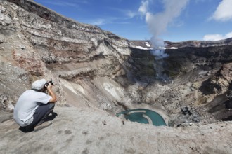 KAMCHATKA, RUSSIA, JULY 21, 2013: Tourist in the crater active Gorely Volcano shoot of the volcano