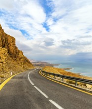 The highway runs along the coast of the Dead Sea. Wonder of nature - the Dead Sea. Cloudy and warm