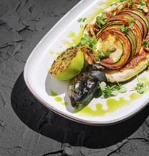 Food, A beautifully plated dish showcases grilled fish shaped like a turtle, complemented by a