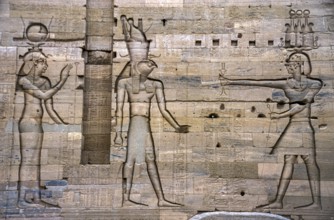 Scanned historical colour photo of relief-like pharaohs and gods carved into a wall in the temple