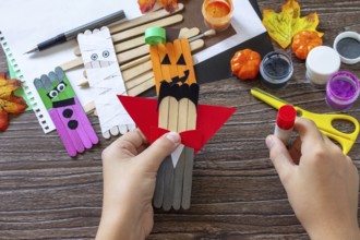Instructions, step 6. Halloween ghost and vampire toy gift stics puppets on wooden table. Handmade.