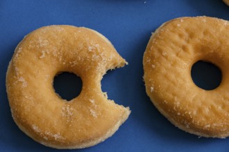 Bitten donut on blue background