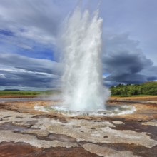 Iceland in the summer. Gushing geyser Strokkur. High column of hot water and steam from the crater