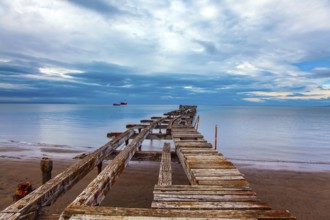South America. Ruined ocean pier in Punta Arenas. The wooden dock flooring collapsed and rotted.