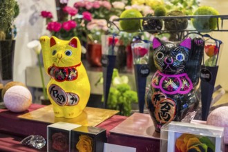 Colourful Maneki-neko figures in a Japanese shop window