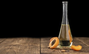 Portion of Apricot Oil with some fresh fruits as detailed close up shot (selective focus)