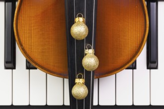 Top view close up shot of piano keyboard, old violin and Christmas decoration. Flat Lay Image