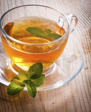 Mint tea in glass cup on wooden table