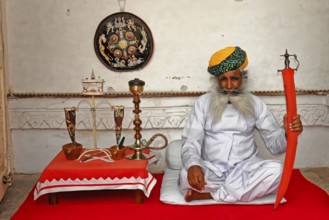 Jodhpur, Rajasthan, North India, Asia, Seated man with a sword and traditional clothes in a