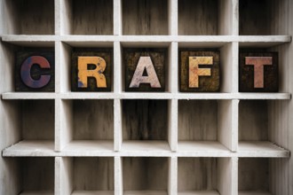 The word CRAFT written in vintage ink stained wooden letterpress type in a partitioned printer's