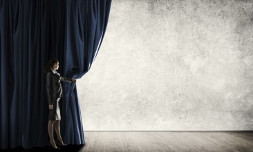 Young woman with megaphone in business suit opening color curtain