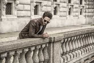 Attractive young man outdoor wearing leather jacket, in European city, Turin in Italy