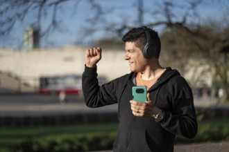 Man listening to music outdoors with headphones. Expression of happiness