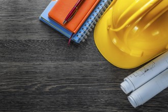 Construction drawings building helmet notepads pen on wood board