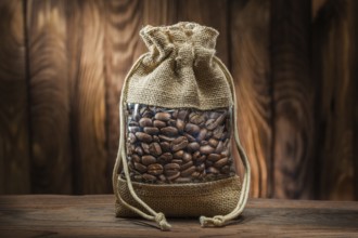 Vintage burlap bag with coffee beans on old wooden background