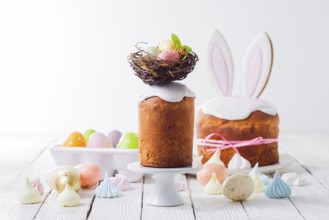 In the foreground an Easter cake decorated with a nest on the top. Painted eggs in the nest. In the