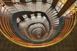 Detailed spiral staircase with orange-coloured banister and tiled floor, fascinating and artistic,