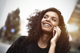 Happy beautiful woman walking and writing or reading sms messages