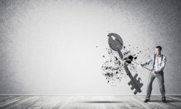 Determined businessman in empty interior breaking with hammer stone key figure