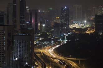Night Kuala Lumpur, Malaysia. City architecture, train and car traffic on illuminated roads
