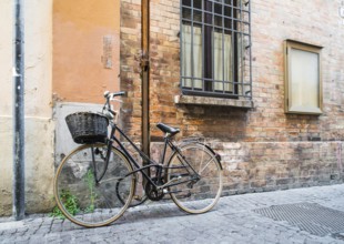 Old Italian bicycle on sunlight. Ancient buildings