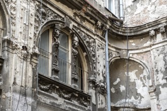 Dilapidated old building façade with stucco and ornaments