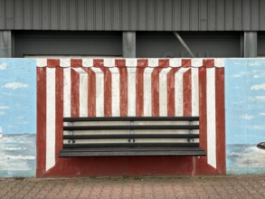 Bench with mural on a wall in the harbour, depicting a beach chair, Norderney