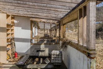 Chungju, South Korea, March 20, 2020: Back patio with decaying wooden picnic table at abandoned
