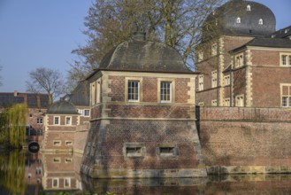 A pavilion and a brick castle reflected in the calm waters of a moat, ahaus, münsterland, germany